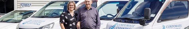 Phil and Raewyn Jackson Owners of Corporate Cleaning Solutions standing in front of cleaning vehicles